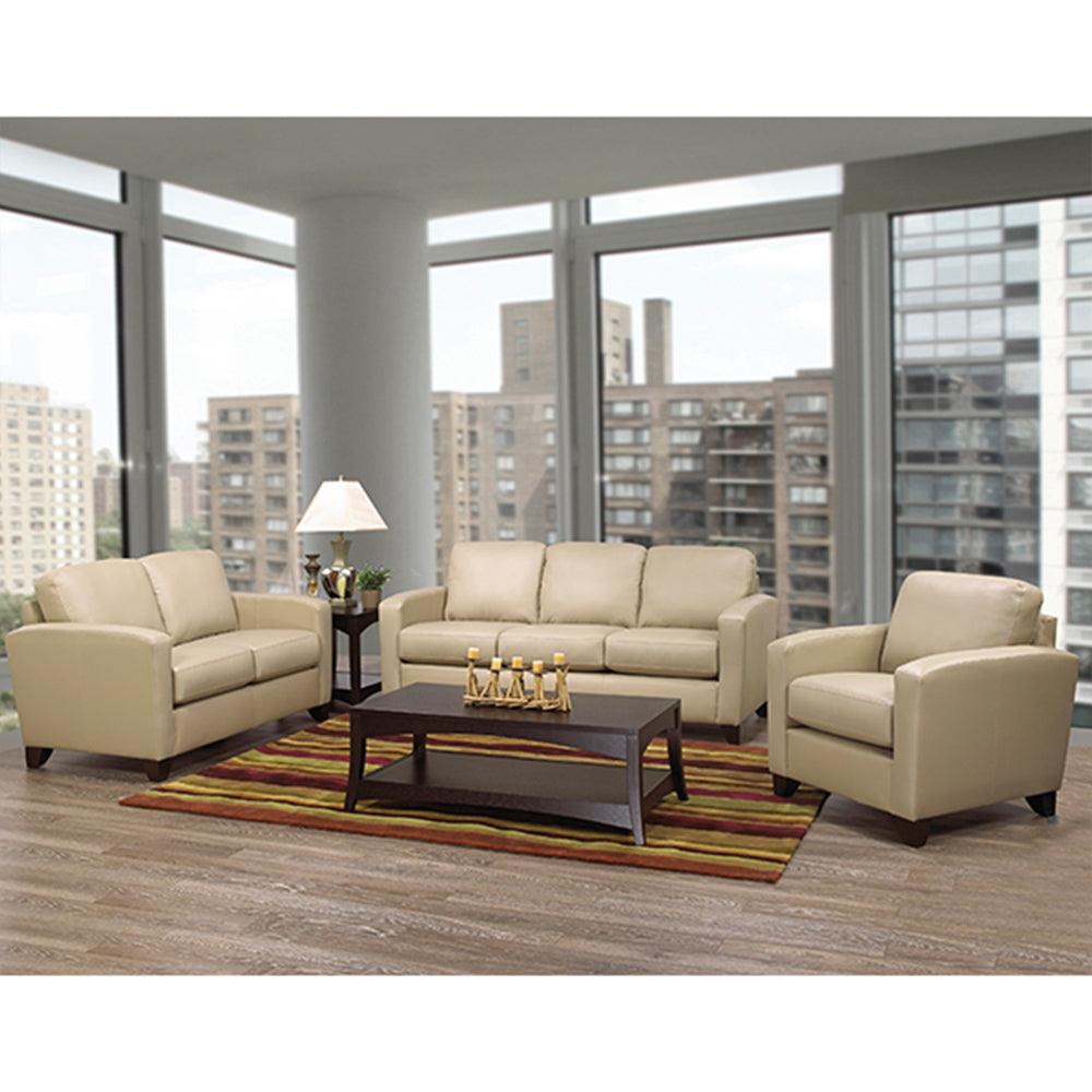Beige living room furniture set with a coffee table in a room with large windows.